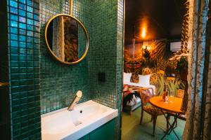 La salle de bains est pourvue d'un lavabo et d'une table. dans l'établissement Domaine Bohème I art de vivre, à Guebwiller