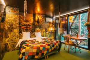 1 dormitorio con 1 cama con una manta colorida en Domaine Bohème I art de vivre en Guebwiller