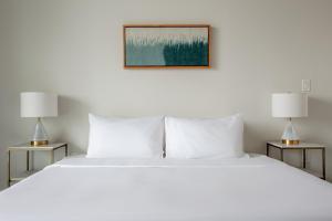 a bedroom with a large white bed with two lamps at Kasa 2nd Street Austin in Austin