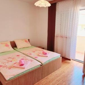 Apartmani Gizela في تروغير: غرفة نوم مع سرير وفوط وردية عليه