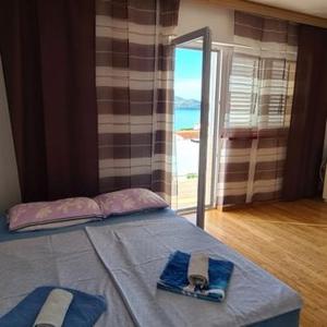 a bedroom with a bed with a view of the ocean at Apartmani Gizela in Trogir