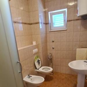 特羅吉爾的住宿－Apartmani Gizela，一间带卫生间、水槽和窗户的浴室