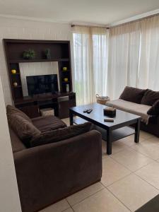 a living room with a couch and a coffee table at Hermosa casa en la serena in La Serena