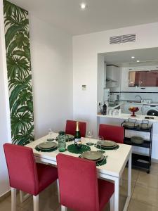 uma sala de jantar com uma mesa e cadeiras vermelhas em Casa Palmera - El Bosque - Playa Flamenca em Playa Flamenca