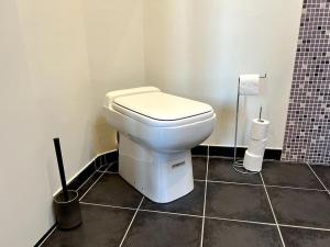 La salle de bains est pourvue de toilettes blanches. dans l'établissement Appartement calme au coeur du jardin, à Violaines