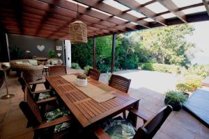 un patio con mesa de madera y sillas en Luxury 10 sleeper with pool and awesome seaview, en Freeland Park