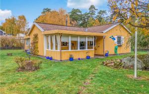 una pequeña casa amarilla con patio en Nice Home In Slvesborg With Wifi en Sölvesborg