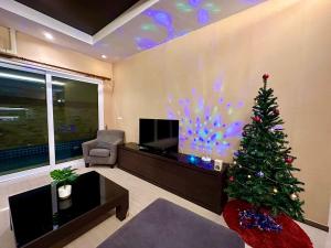 a living room with a christmas tree and a tv at Tinker Bell Pool Villa in Jomtien Beach