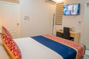 a bedroom with a bed and a desk and a tv at Tourist Inn Grand in Male City