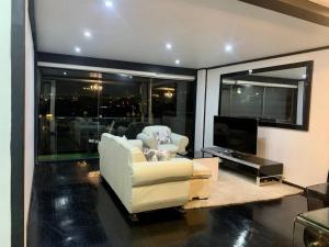 墨西哥城的住宿－Elegante PH minimalista en Parque México，客厅配有两把椅子和电视
