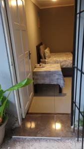 a room with a bed and a table next to a door at Budget self-contained room in Pretoria