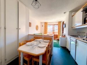 eine Küche mit einem Tisch mit Schalen und Tellern darauf in der Unterkunft Appartement Les Menuires, 2 pièces, 4 personnes - FR-1-344-1078 in Les Menuires