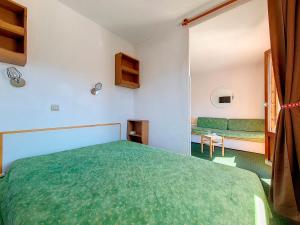 ein Schlafzimmer mit einem grünen Bett und einem Sofa in der Unterkunft Appartement Les Menuires, 2 pièces, 4 personnes - FR-1-344-1078 in Les Menuires