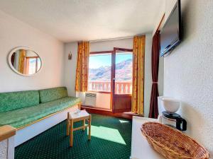 ein Wohnzimmer mit einem grünen Sofa und einem Fenster in der Unterkunft Appartement Les Menuires, 2 pièces, 4 personnes - FR-1-344-1078 in Les Menuires
