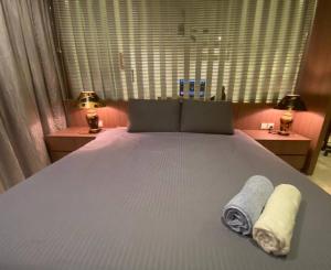 1 dormitorio con 1 cama con 2 toallas en KSL City Mall Bathtub 1-4pax Netflix JB City en Johor Bahru