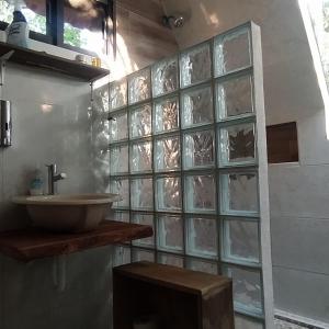 a bathroom with a sink and a glass block wall at Eco Aldea kinich Ahau in Xpujil