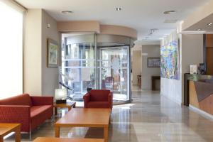 a lobby with two red chairs and a table at Hotel Olympia Ronda II in El Puig