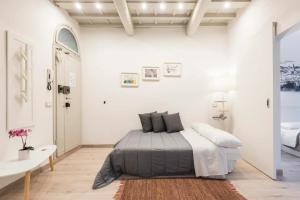 - une chambre blanche avec un lit et une table dans l'établissement Cozy apartment near Ponte Vecchio, à Florence