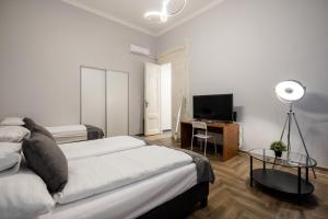 1 dormitorio con 2 camas y escritorio con TV en Prime Time Vaci Budapest, en Budapest
