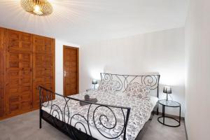 a bedroom with a black and white bed and a chandelier at Casa Hola Mar in Los Realejos