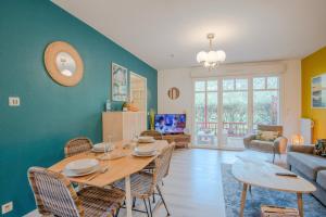 a living room with a table and chairs at Résidence du Haurat in Gujan-Mestras