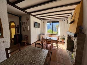 a living room with a table and chairs and a fireplace at Casa Jara in Jimera de Líbar