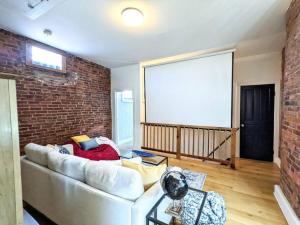 ein Wohnzimmer mit Sofa und Ziegelwand in der Unterkunft HostWise Stays - Industrial Vintage Style, Minutes to Downtown in Pittsburgh