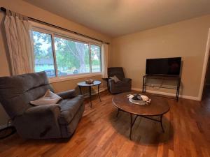 a living room with a couch and a table and a tv at Spacious 4 bedroom residential at Burlington Park in Billings