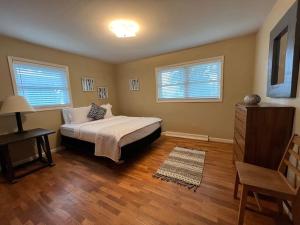 a bedroom with a bed and a table and two windows at Spacious 4 bedroom residential at Burlington Park in Billings