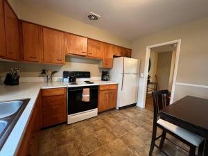 a kitchen with wooden cabinets and a white refrigerator at Spacious 4 bedroom residential at Burlington Park in Billings +11 photos