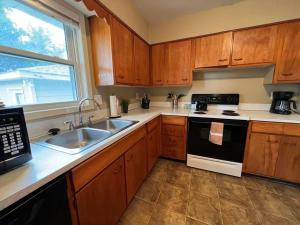 a kitchen with wooden cabinets and a sink and a stove at Spacious 4 bedroom residential at Burlington Park in Billings