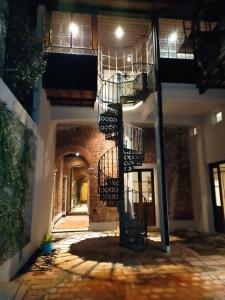 a building with a spiral staircase in a courtyard at night at La Botica de 1852 Hotel in Chascomús