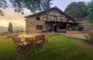 a table and chairs in front of a stone house at Relax, montaña, paz in Errezil