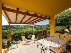 a house with a table and chairs on a patio at VILLA CLAUDIO e LUNETTA in Villasimius