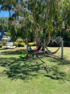 a person laying in a hammock under a tree at Icalma De La Sierra in Tandil