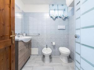 a white bathroom with a toilet and a sink at VILLA CLAUDIO e LUNETTA in Villasimius