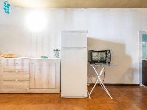 a white refrigerator in a kitchen with a tv at VILLA CLAUDIO e LUNETTA in Villasimius