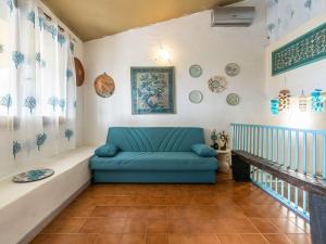 a living room with a blue couch in a room at VILLA CLAUDIO e LUNETTA in Villasimius