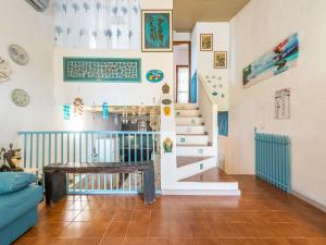 a living room with a staircase and a blue couch at VILLA CLAUDIO e LUNETTA in Villasimius