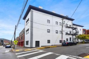 a white building on the corner of a street at HostWise Stays - Butler St, Lower Lawrenceville, Brand New! in Pittsburgh