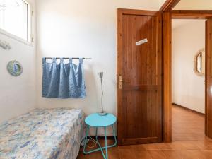 a bedroom with a bed and a table and a door at VILLA CLAUDIO e LUNETTA in Villasimius