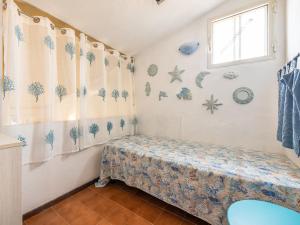a small bedroom with a bed and a window at VILLA CLAUDIO e LUNETTA in Villasimius