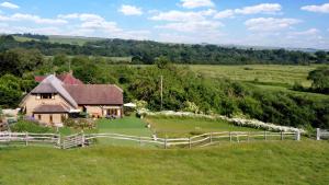 a house in the middle of a field with a fence at Exclusive Use of A Barn in Arundel