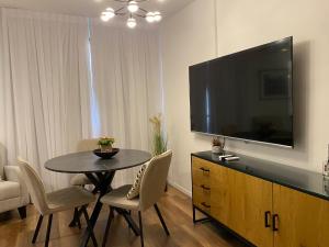 Il comprend un salon doté d'une table et d'une télévision à écran plat. dans l'établissement דירת בוטיק Dnine7, à Haïfa