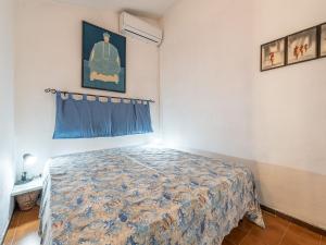 a bedroom with a bed with a blue bedspread at VILLA CLAUDIO e LUNETTA in Villasimius