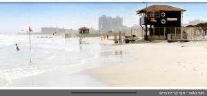 - une vue sur la plage où les gens jouent dans l'eau dans l'établissement דירת בוטיק Dnine7, à Haïfa