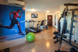 a gym with a poster of a man running and a ball at The Sun Flat Beira Lago in Brasília