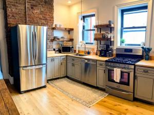 a kitchen with a stainless steel refrigerator and stove at HostWise Stays - The Ohioan - Beautiful Brick Apt, Minutes to Downtown! in Pittsburgh