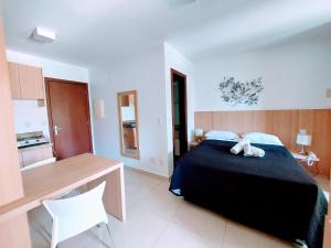 a bedroom with a large bed and a table at The Sun Flat Beira Lago in Brasília