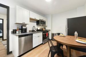 cocina con mesa y nevera negra en HostWise Stays - Pet Friendly Butler St Apt, Ground Floor with Private Entrance en Pittsburgh